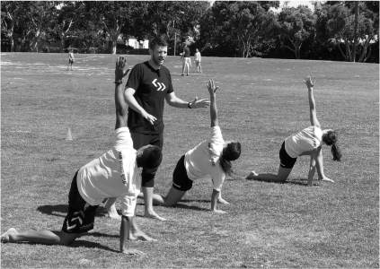 Coach instructing athletes through warmup movements